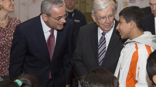 Elder M. Russell Ballard (rechts) vom Kollegium der Zwölf Apostel und Elder Patrick Kearon, Präsident des Gebiets Europa, hören einem Jungen in einer Flüchtlingsunterkunft in Berlin zu.
